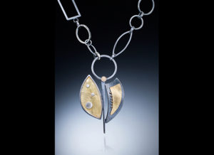 NKL–61: Embossed 22-karat gold on silver, oxidized silver, Pendant 2.75 x 1.75 inches, chain 20 inches. $750.00