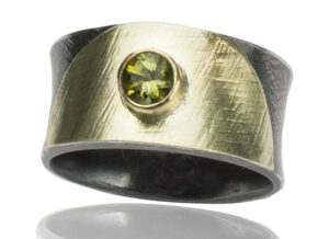 R–18: Peridot 5mm set in 18k gold, with 22k gold on oxidized sterling silver.Size 7.25. $500.00 